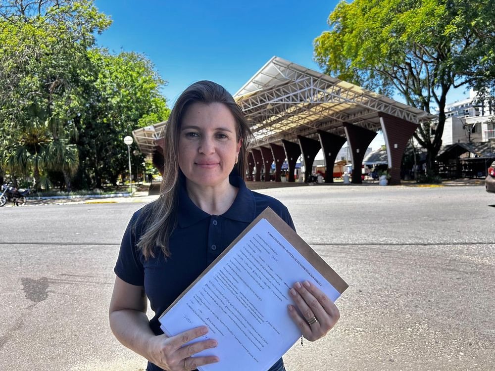 Ana Paula Melo segura uma prancheta com formulários sobre o impacto do fechamento da Rua Coberta